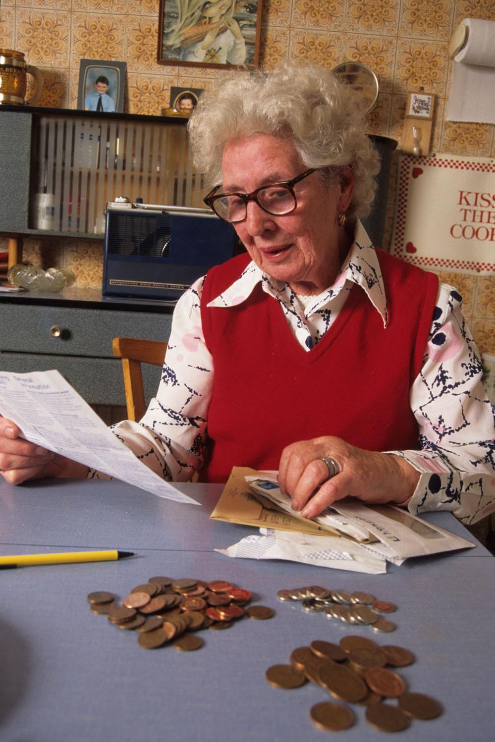 Picture of lady in red pullover counting her pennies.